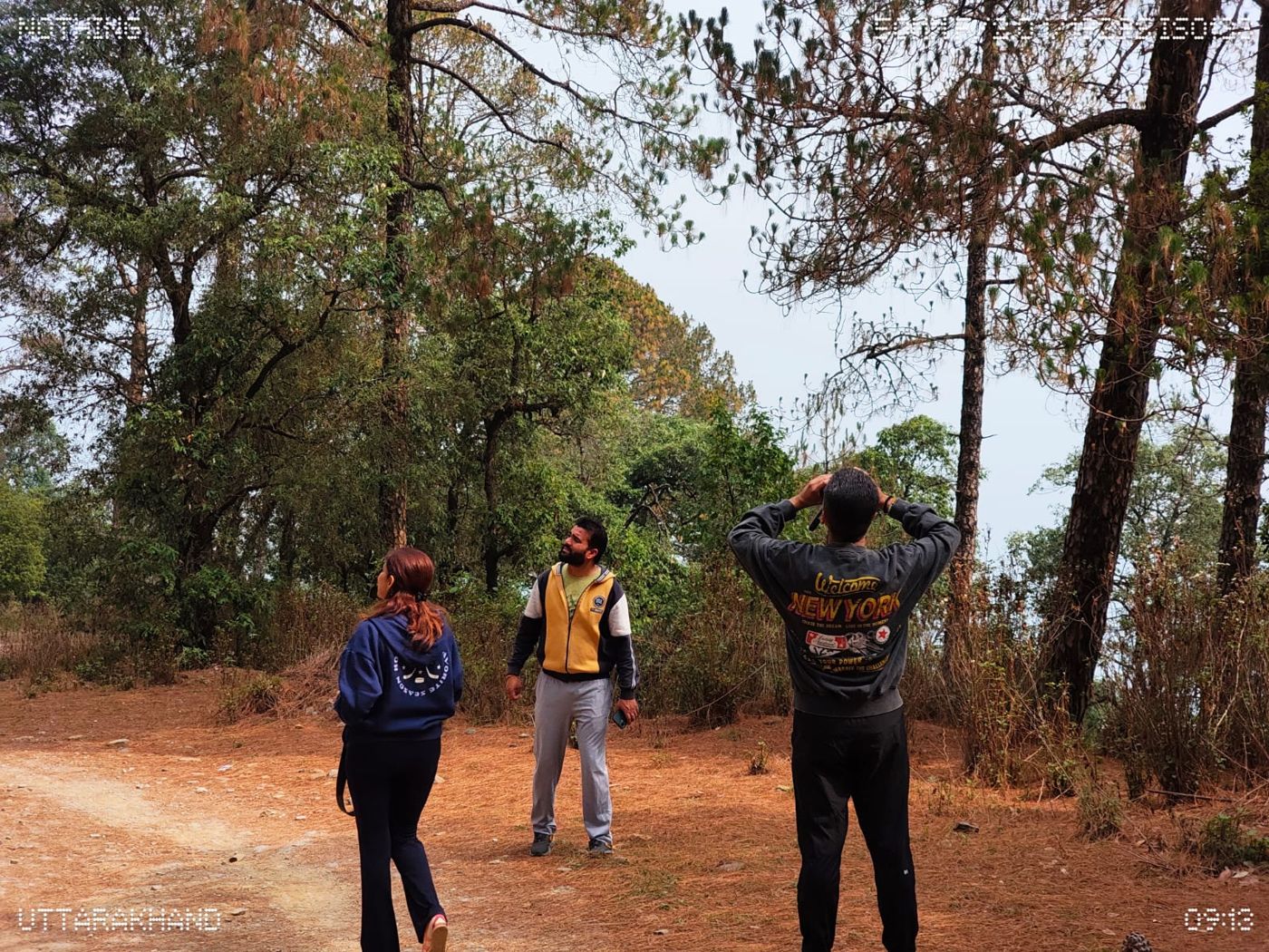 Guide pointing out birds to trekkers in the forest